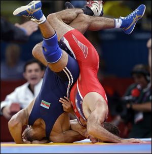 American Coleman Scott, left, takes on Azerbaijan's Toghrul Asgarov in a men's 60-kg freestyle semifinals. Asgarov topped Scott en route to gold.
