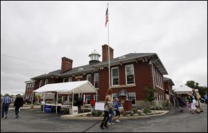 People gather for a centennial celebration at the former Monclova School, which now houses the Monclova Community Center. The structure had been vacant since the early 1970s and faced demolition in 1997. But a dedicated group of community members saved it from the wrecking ball. The festival Saturday
featured refreshments, crafters, carriage rides, a parade with antique automobiles and tractors, and a silent auction.