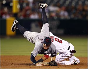 Cleveland Indians' second baseman Jason Donald is upended but completes the double play on Los Angeles Angels' Erick Aybar at second and Chris Iannetta at first in the fifth inning of Monday night's game in Anaheim, Calif.