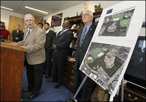 Dan Pritt of Athletic Alliance, left, explains the layout of the proposed development as Mayor Mike Bell, center, and Deputy Mayor Tom Crothers look on. 