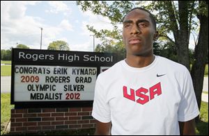 Erik Kynard, Jr. poses in front of a congratulatory sign on Friday at Rogers High School. Kynard -- a Rogers graduate -- won the silver medal in the high jump this month at the London Olympics. Kynard became the first Toledoan to win an individual Olympic medal since Edmund Coffin won gold in equestrian in 1976. Coffin moved away when he was 2.