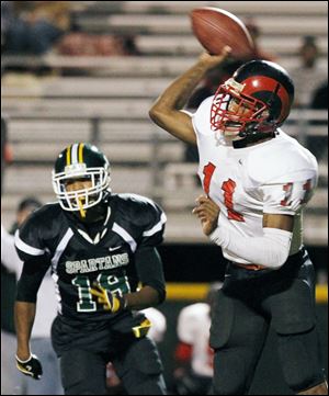 Rogers quarterback Keandre Gilmer passes as Start's Arthur Phillips gives chase. Both return this season.