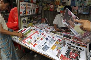 Customers buy local weekly journals at a roadside shop in Yangon, Myanmar. Myanmar's government said Monday it was abolishing the harsh practice of directly censoring the country's media.