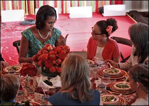 First lady Michelle Obama talks with Illana Gonzalez-Evans, from Washington, during the Kids' 'State Dinner,'  Monday in the East Room of the White House.