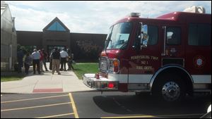 People who were evacuated from Owens' Math-Science Center on Tuesday stand on the sidewalk as he Perrysburg Township Fire Department responds to the scene.