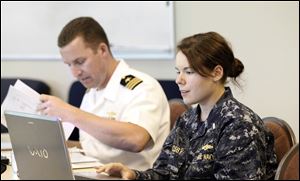 Cmdr. Jamie Achee and Lt. j.g. Tiffany Crosby work at the Command Center at One Maritime Plaza in preparation for Navy Week. Ships are to arrive Thursday and be open for tours Friday to Sunday.