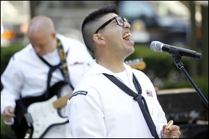 Jeremy Bustillos belts out a song during a Navy Band performance in downtown Toledo. The group played a set of Top 40, rock, Motown, and country songs.