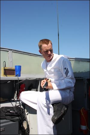 Seaman Travis Steer of Rossford, plays his guitar aboard the USS Hurricane. He was assigned to the ship after basic training.