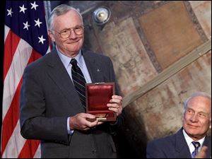 Apollo 11 astronaut, and the first man to walk the moon, Neil Armstrong, left, holds the Langley Gold Medal after it was presented to him by Vice President Al Gore Tuesday, July 20, 1999 at a ceremony at the Smithsonian Air And Space Museum in Washington. Fellow recipient Edwin A. 