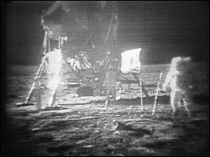 In this July 20, 1969 black-and-white file photo, taken from a television monitor, Apollo 11 astronaut Neil Armstrong, right, trudging across the surface of the moon.  Edwin E. Aldrin is seen closer to the craft.  NASA may not be going to the moon anytime soon and its space shuttles are about to be retired, but it could conceivably increase the number of agency jobs under a new reorganization, NASA's chief said Thursday.