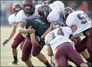 Genoa defensive players swarm to tackle Will Longthorne of Ottawa Hills, which was held to 36 yards rushing and 95 yards passing.