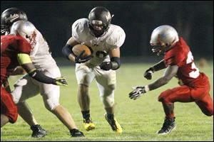 Perrysburg running back Kenneth Zimmerman finds a hole for a gain during the third quarter of Friday evening's game at Bowsher.