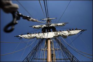 Crew members of the U.S. Brig Niagara work high above the deck to roll a sail during the Lake Erie trip.