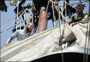 Isaiah Young of Greenville, Ohio, rolls up a sail on the U.S. Brig Niagara. He was among those participating in Saturday's day-long sail on Lake Erie.