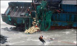 A Chinese fisherman is rescued Tuesday by South Korean coast guard officers from a Chinese ship in Jeju,  South Korea, after a typhoon slammed his ship into rocks off the southern coast. 