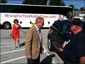 Ted Strickland, center, speaks to people at the East Toledo stop of his anti-Mitt Romney bus tour Tuesday.