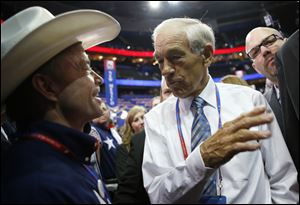 Rep. Ron Paul, R-Texas, talks with a Texas delegate on the floor at the Republican National Convention in Tampa, Fla., on Tuesday.