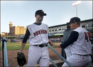 Duane Below, left, goes into the dugout after allowing three earned runs in four innings of work on Tuesday night. To the right is Zach Miner.