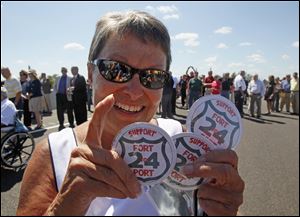 Sue Westendorf shows off some of the buttons she brought to hand out at the ribbon-cutting ceremony for Ohio's final portion of U.S. 24. 
