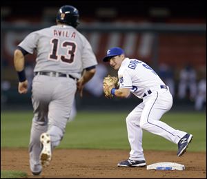 Kansas City Royals second baseman Johnny Giavotella, right, prepares to throw to first for the double play hit into by Detroit Tigers' Austin Jackson after forcing Alex Avila (13) out at second during the third inning in Kansas City.