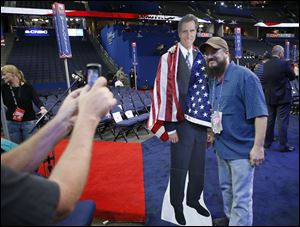 Travis Chapin of St. Petersburg, Fla., poses with a life-sized cutout of Mitt Romney on the floor of the Republican National Convention.