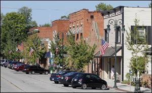 Cars are parked along Front Street in Grand Rapids. The town lost its hardware store, its grocery, and its pharmacy. Then Dorinda Shelley bought a gift-shop business and renovated it.