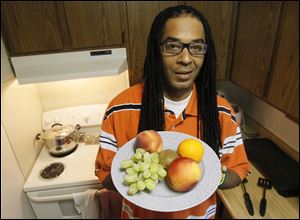 Ishmael Shakur holds a plate of fruit at his home in Toledo.