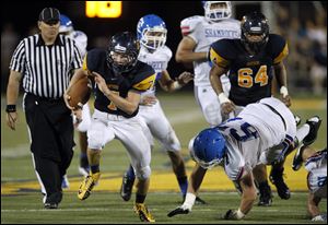 Whitmer quarterback Nick Holley darts up the middle for one of his two second-half touchdowns.