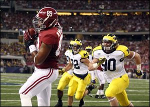 Alabama tight end Michael Williams, left, pulls in a touchdown pass in front of Michigan linebacker Jake Ryan (90) and safety Jordan Kovacs during the first half Saturday night at Cowboys Stadium in Arlington, Texas. Michigan lost 41-14.