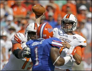 BG quarterback Matt Schilz attempts a pass while Florida's Jon Bostic rushes. Schilz completed 24 of 49 passes for 204 yards in the Falcons' 27-14 loss.
