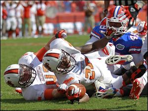 Bowling Green running back John Pettigrew dives past Florida linebacker Darrin Kitchens for a one-yard touchdown run in the first quarter. He had 38 yards on eight attempts in the loss.