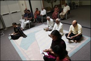 Members pray during worship at the Hindu Temple in Sylvania Township. Ground for the site was broken in 1986, and the temple was completed in 1989.