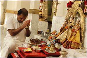 Pandit Anantkumar B. Dixit prays with his congregation at the Hindu Temple in Toledo, formed in the early 1980s.