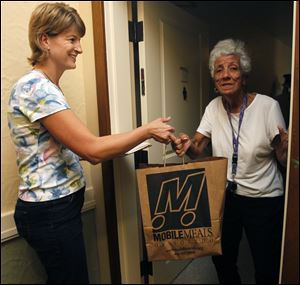Annette Clark, director of Family Service of Northwest Ohio, delivers a meal to Barbara Lambert at the Renaissance Senior Apartments in Toledo. Mobile Meals is looking for at least 50 volunteers.