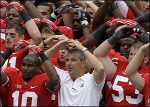 Ohio State coach Urban Meyer, center, cleared out space next to Garrett Goebel, right, as the Buckeyes lined up to sing the alma mater following Saturday's season-opening win against Miami (Ohio).