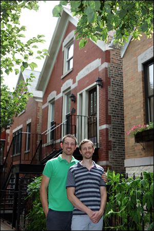 Brian McCord, left, and Jamie Blondin stand outside their Chicago flat. When the couple saw other buyers touring the home with a tape measure, they offered 96 percent of the $649,000 asking price.
