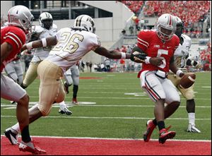 Ohio State quarterback Braxton Miller (5) scores a touchdown  against Central Florida defender Clayton Geathers (26) during the second quarter.