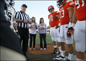 Bowling Green State University students Kayla Somoles, left, and Angelica Mormile, join the coin toss as honorary captains before the Bowling Green State University vs Idaho football game at Doyt Perry Stadium.