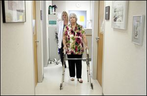 Heart valve replacement surgery patient Barbara Streight of Toledo walks with the aid of a walker to see Dr. Michael G. Moront.