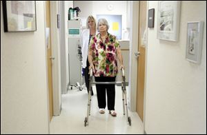Heart valve replacement surgery patient Barbara Streight of Toledo walks with the aid of a walker to see Dr. Michael G. Moront.
