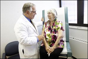 Dr. Michael G. Moront of Promedica Toledo Hospital goes through the first follow-up visit with heart valve replacement surgery patient Barbara Streight.