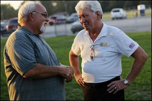 Steve Heer of Lambertville, left, talks with Bedford Township Supervisor Walt Wilburn. The incumbent, who lost the GOP primary, explained the procedures for voting for write-in candidates.