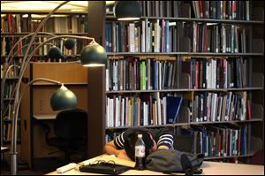 Taewon Kim, an electrical engineering systems graduate student,
sleeps in the library at the Duderstandt Center on the campus of the
University of Michigan in Ann Arbor.