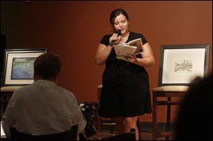 Lourdes graduate Charity Anderson reads her poem at a college journal's reception. More people are hearing about strong Lourdes programs, one professor says.