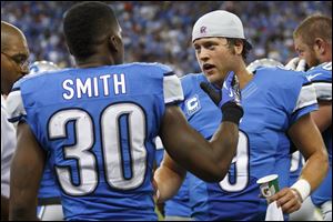 Detroit Lions running back Kevin Smith, left, receives congratulations from quarterback Matthew Stafford after scoring the game-winning touchdown in the fourth quarte rSunday in Detroit. Stafford  threw three first-half interceptions, but in the end, he made the difference for the Lions.