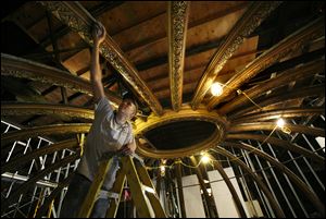 Philip Borkowsi of Heyne Construction, Inc., cleans ornate tin on the domed ceiling of the Van Wert County Courthouse.  A drop ceiling has been removed and the original domed ceiling is being restored.  