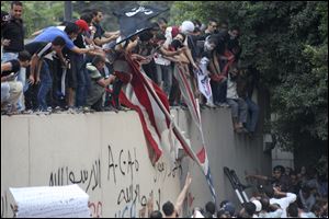 Protesters destroy an American flag pulled down from the U.S. embassy in Cairo, Egypt. Egyptian protesters, largely ultra conservative Islamists, have climbed the walls of the U.S. embassy in Cairo, went into the courtyard and brought down the flag, replacing it with a black flag with Islamic inscription, in protest of a film deemed offensive of Islam. 