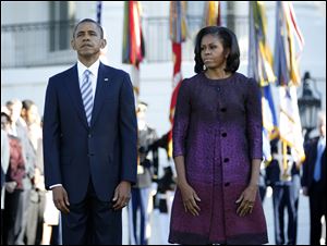 President Barack Obama and first lady Michelle Obama, joined by members of the White House staff, pause today before a moment of silence to mark the 11th anniversary of the Sept, 11th on the South Lawn of the White House