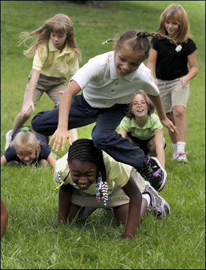 Samantha Wells, a Navarre Elementary third grader, vaults over Mahogany Lewis in a game of leapfrog that was part of Peter Navarre Day in Navarre Park.