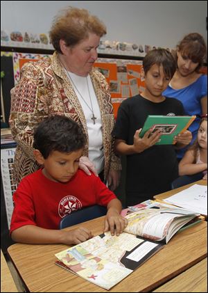  Sister Frances Marie watches Augustine Vallejo, 7, and his brother Armando Vellejo, right, as they choose free books.